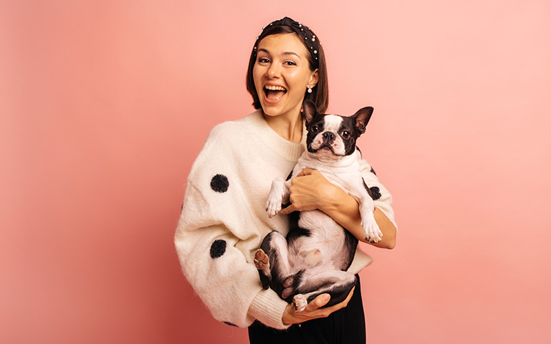 Lady holding a dog while wearing clean clothes free from pet hair after professional removal
