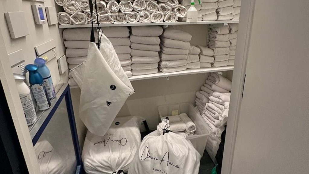 Neatly folded towels and sheets in a commercial laundry stockroom in NYC.